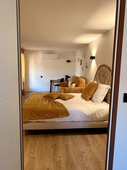 Spacieuse chambre familiale à l'Hôtel les Vieilles Pierres à Eymet avec lit queen-size, literie dorée, bureau et équipements modernes