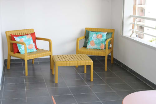 Salon moderne avec deux fauteuils jaunes et pouf chez Maisons En Or Cayenne, décoration colorée