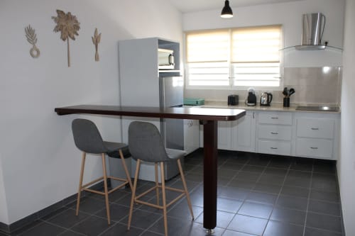 Cuisine moderne et coin repas de l'appartement T2 Hibiscus à Maisons En Or, Cayenne, avec bar et équipements complets