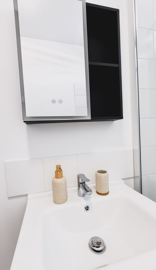 Lavabo de salle de bain moderne avec plan de travail en marbre, robinetterie et articles de toilette à l'hôtel Maisons En Or à Cayenne