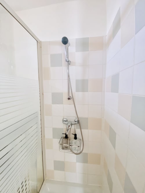 Salle de douche moderne avec douchette et carrelage à damier à l'appartement Maisons En Or à Sinnamary