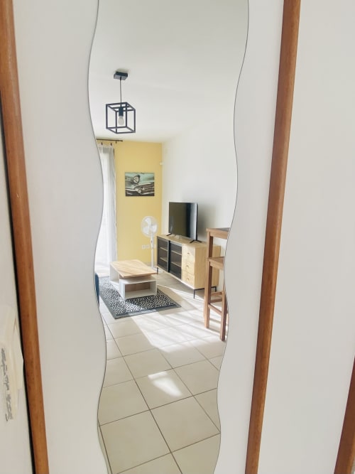 Séjour moderne aux Maisons En Or à Sinnamary avec mur accent jaune, téléviseur, mobilier bois et carrelage