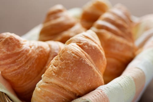 Croissants frais dans un panier aux Apartamentos Mimare Denia, un hôtel à Denia en Espagne proposant un service de petit-déjeuner de qualité.
