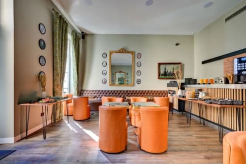 Moderna lounge nel foyer del Boutique Hôtel Provencia a Marsiglia con sedute arancioni e arredamento elegante