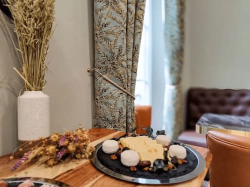 Elegante tagliere di formaggi e salumi presentato al Boutique Hôtel Provencia di Marsiglia, con fiori secchi e decorazioni