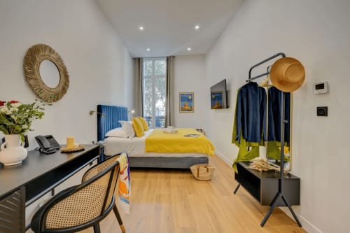 Camera moderna al Boutique Hôtel Provencia di Marsiglia con biancheria gialla, accenti blu, scrivania e appendiabiti