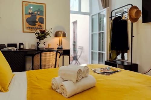 Camera moderna del Boutique Hôtel Provencia a Marsiglia con biancheria gialla, asciugamani arrotolati e arredamento contemporaneo