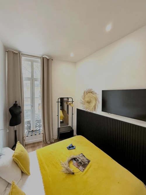 Camera moderna al Boutique Hôtel Provencia di Marsiglia con biancheria gialla, parete nera e vista sulla città