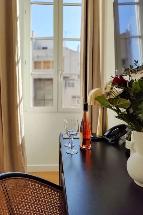 Camera del Boutique Hôtel Provencia con vino, fiori e vista sulla città di Marsiglia dalle finestre