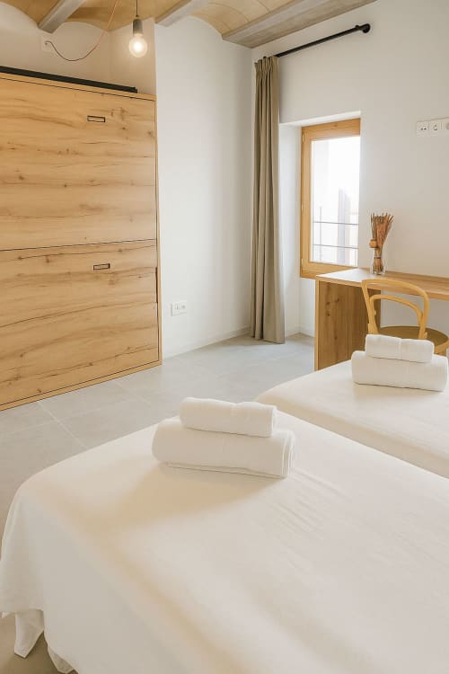 Habitació moderna a L'Algars Boutique Hotel de Tarragona amb llit Murphy de fusta, roba de llit blanca i vistes a la ciutat