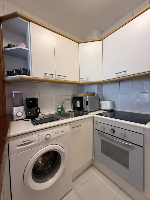 Cocina moderna en apartamento de Fuengirola con lavadora, horno, microondas y encimeras equipadas