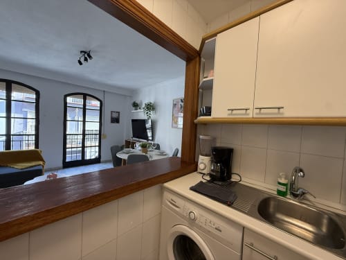 Cocina moderna con vistas a la ciudad que se abre a la sala de estar en apartamento de Fuengirola