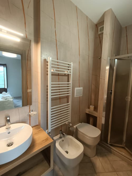 Bagno moderno in Affittacamere Il Portale, Spinoso con lavabo bianco, wc, bidet, scaldasalviette e cabina doccia