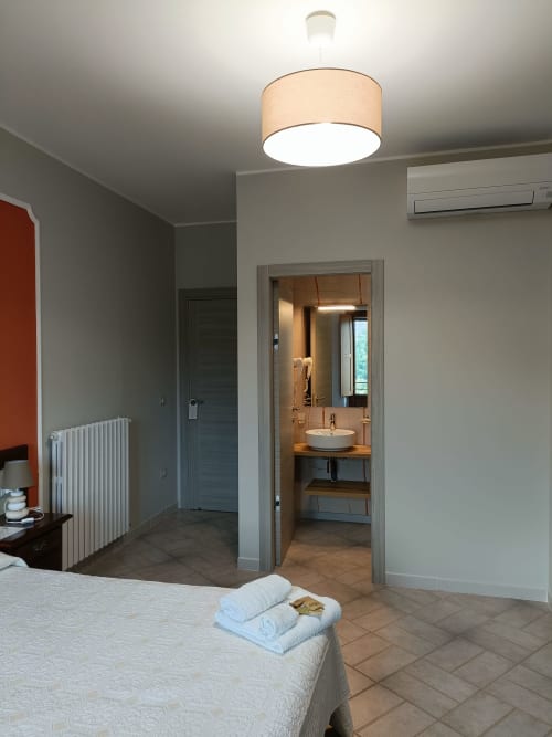 Ampia camera con bagno en-suite all'hotel Il Portale di Spinoso, dotata di illuminazione moderna e aria condizionata