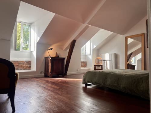Chambre spacieuse sous les combles aux Anciennes écuries du Château, avec poutres apparentes, vue sur le jardin et mobilier d'époque