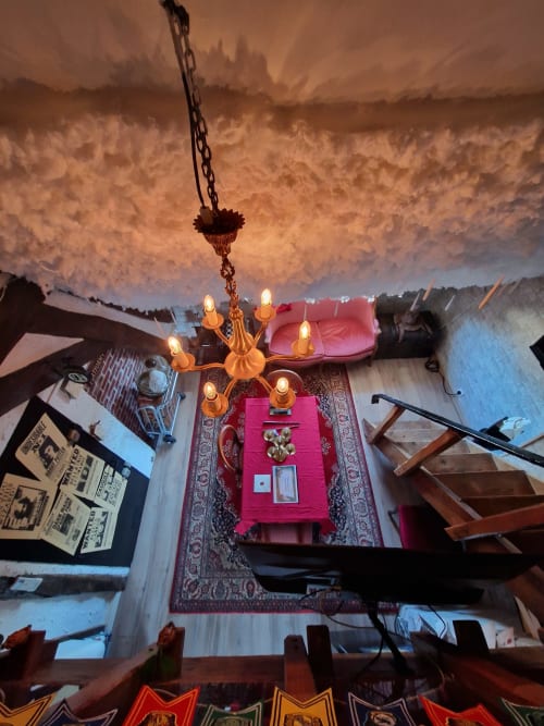 Vue de dessus de la chambre L'école des sorciers à l'hôtel Accolade à Châteaudun avec lustre lumineux, mobilier rose et