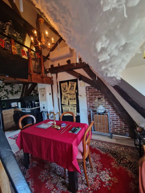 Salle à manger thématique Harry Potter à l'hôtel Accolade, Châteaudun, avec nappe rouge et affiches de recherche