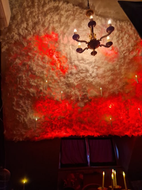 Plafond enchanté avec projection de nuages rouges et lustre orné dans l'appartement immersif L'école des sorciers d'Accolade