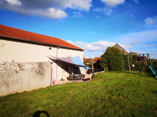 Garden view of À tout Coeur cottage at Les Charmises, Charroux with play area and shaded seating