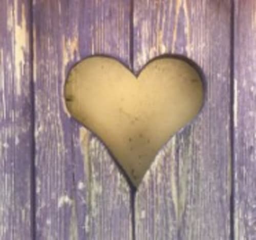 Cream-colored heart shape on weathered purple wooden background at Les Charmises cottage, Charroux