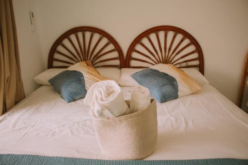 Chambre élégante avec têtes de lit ajourées, coussins décoratifs et panier d'accueil à l'appartement Love Rent4 Malaga