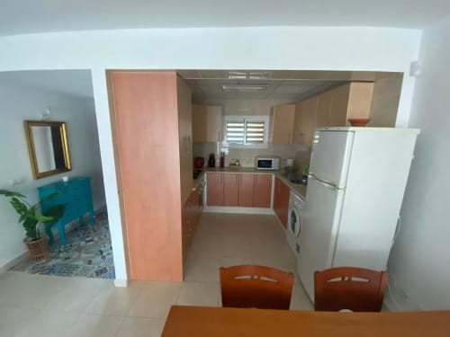 Cuisine moderne et coin repas de l'appartement Love Rent4 à Torremolinos, avec meubles en bois, électroménagers et table à manger