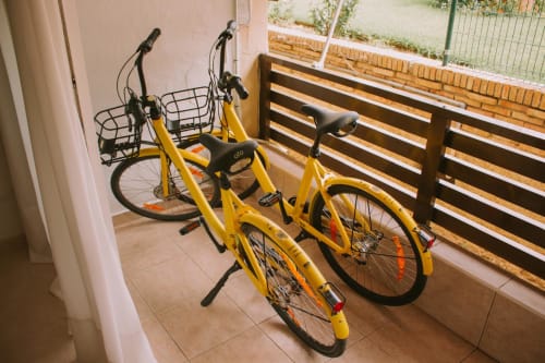 Deux vélos jaunes avec paniers garés sur la terrasse de l'appartement Love Rent4 à Malaga, Torremolinos