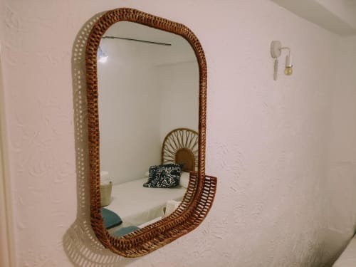 Miroir avec cadre en rotin tressé reflétant une chambre aux draps blancs dans l'appartement Love Rent4 à Málaga, Torremolinos