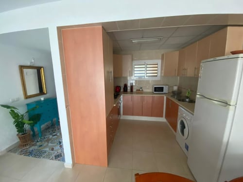 Cuisine moderne avec placards corail, électroménagers blancs et carrelage dans l'appartement Love Rent4, Torremolinos