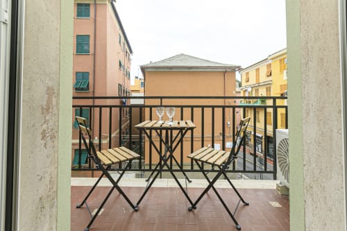 Balcone privato con sedute dell'appartamento Rosa House a Genova, affacciato su edifici colorati e vista sulla città