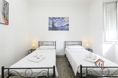 Due letti singoli in camera luminosa alla ML White House, appartamento a Genova con opera di Van Gogh e vista città