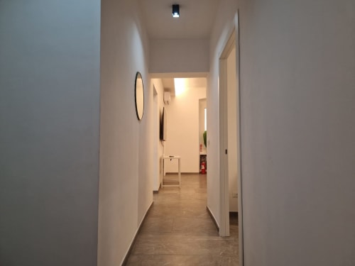 Corridoio moderno dell'appartamento Fresia House presso ML White House a Genova con pareti bianche e pavimenti in piastrelle