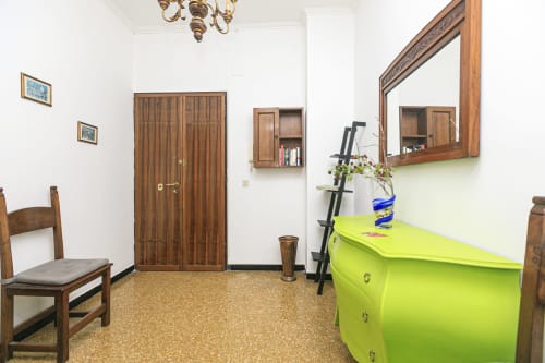 Luminosa hall d'ingresso dell'appartamento Gelsomino House a Genova con cassettone verde lime, guardaroba in legno e specchio