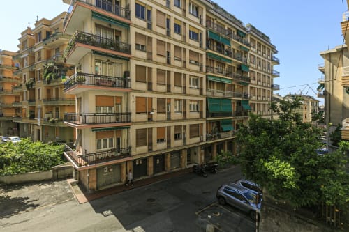 Facciata di edificio residenziale a Genova con muri gialli, balconate e vista sulla strada dell'appartamento GELSOMINO HOUSE