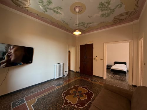 Ampio soggiorno nell'appartamento Tulipano House a Genova, con TV a schermo piatto, soffitto decorativo e pavimento in cotto