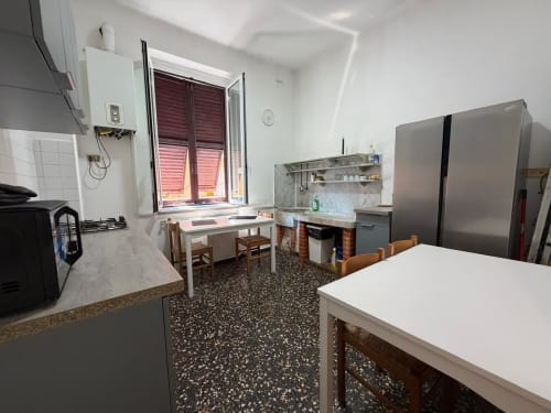 Cucina e zona living moderni nell'appartamento Tulipano House a Genova, con elettrodomestici in acciaio inox e vista sulla città