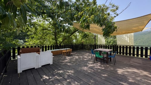 Terrazza in legno di Podere di Maggio con zone d'ombra, area pranzo, vista montagna e verde rigoglioso a Santa Fiora