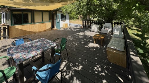 Terrazza in legno di Podere di Maggio a Santa Fiora con tavolo da pranzo, sedie, tenda ombreggiante e vista sulle montagne