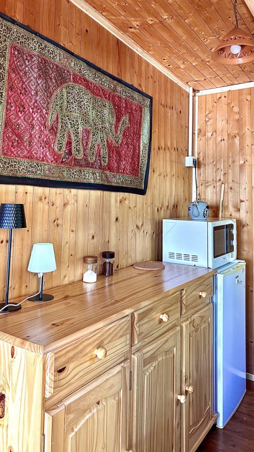 Angolo cucina in legno a Podere di Maggio con arredamento rustico, arazzi rossi e vista sulle montagne, Santa Fiora