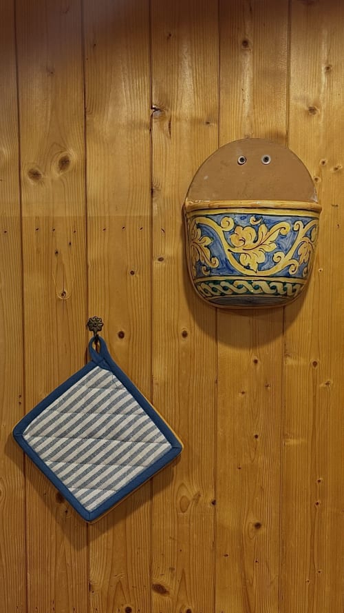 Supporto ceramico decorativo da parete e presina a righe su rivestimento in legno a Podere di Maggio, villa toscana