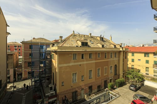 Veduta dell'architettura genovese storica con edifici colorati attorno a una corte centrale a Genova, Italia
