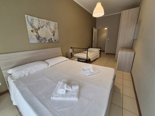 Camera Vanilla House a Genova con letto matrimoniale, biancheria bianca, letto aggiuntivo, aria condizionata e quadri con vista sulla città