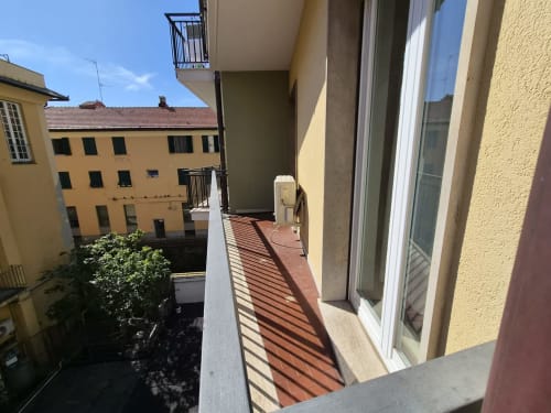 Terrazza del balcone dell'appartamento Vanilla House a Genova con vista sulla città, pavimento in terracotta e edifici gialli circostanti