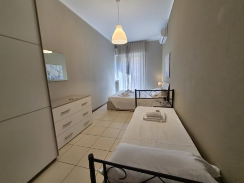 Camera da letto della Vanilla House di ML White House a Genova con letti gemelli, cassettone bianco e accesso al balcone