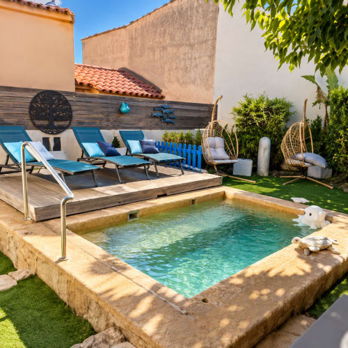 Villa avec vue sur la piscine aux Villas d'A Storia à Lecci : transats, fauteuils suspendus et piscine turquoise
