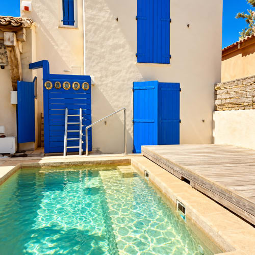 Villa aux volets bleus des Villas d'A Storia avec piscine turquoise et terrasse en bois à Lecci