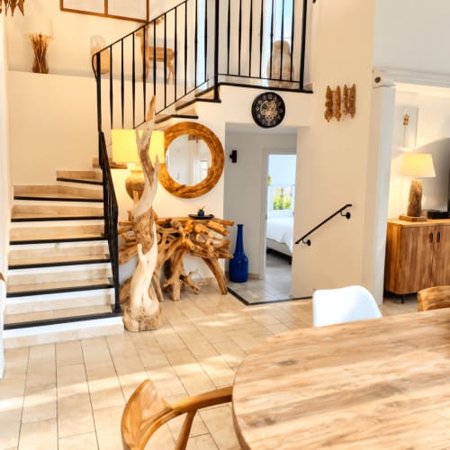 Intérieur de villa moderne aux Villas d'A Storia à Lecci : escalier en bois, décor rustique et salle à manger ouverte