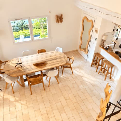 Salle à manger lumineuse de la villa Les Villas d'A Storia avec table en bois, chaises modernes et vue sur la piscine à Lecci