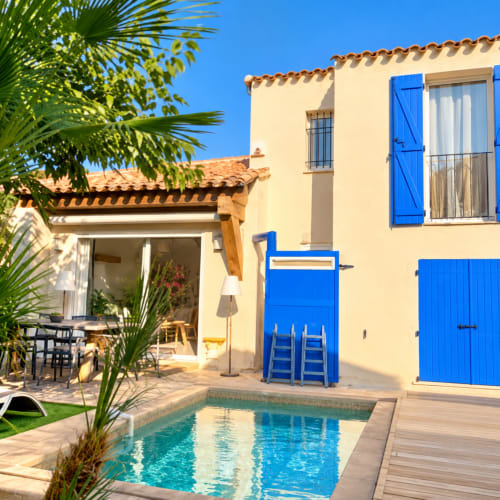Villa Les Villas d'A Storia à Lecci avec volets bleus, vue piscine et jardin méditerranéen avec palmiers