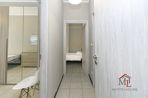 Corridoio moderno dell'appartamento ML White House a Genova, con pavimentazione in piastrelle, armadio specchiato e accesso alla camera